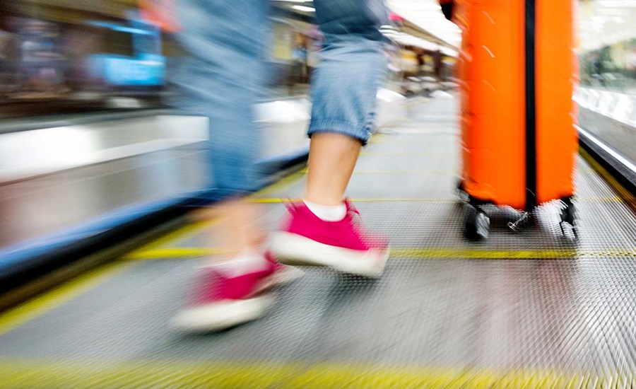 Dame i rulletrapp med koffert, til illustrasjon for trygt med to kort