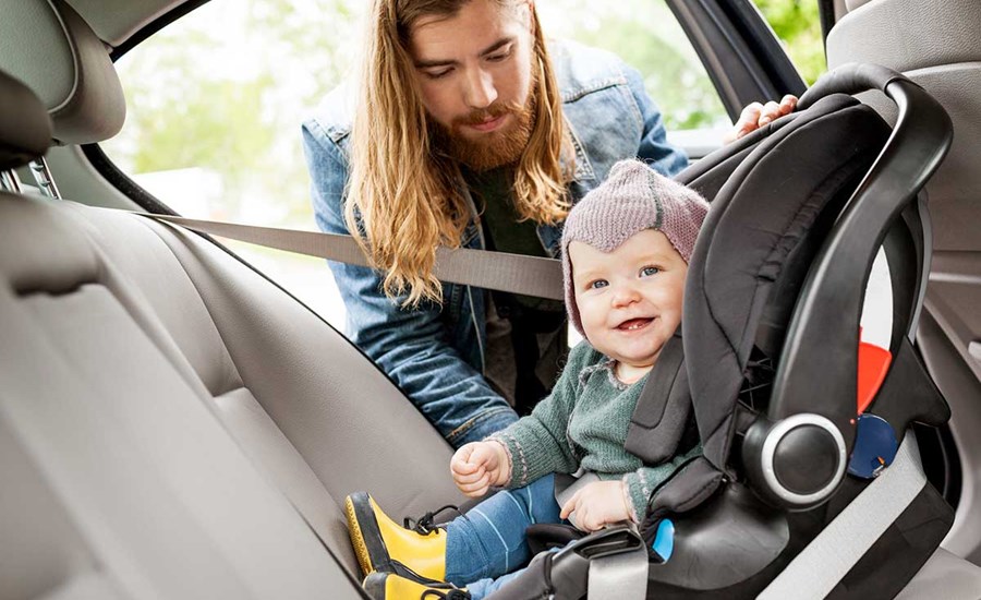 Mann sjekker bilstolen til en baby, til illustrasjon for billån
