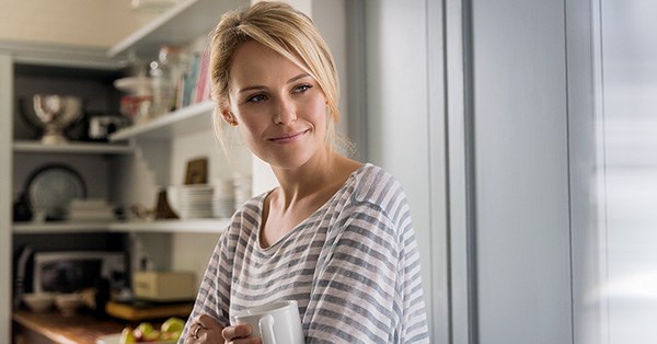 Dame med stripete genser holder kaffekopp