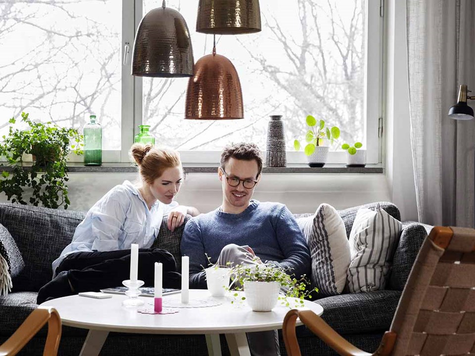 Par sitter sammen i koselig stue - illustrasjon for samboerkontrakt