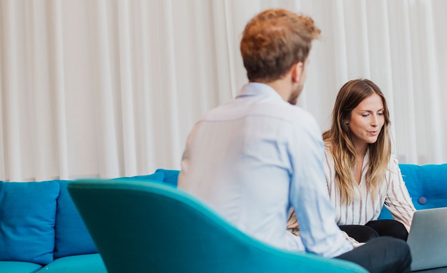 Mann sitter på en stol og en kvinne sitter i en sofa med en PC fremfor seg, til illustrasjon for serielån