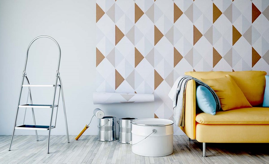 Gul sofa med tapet på veggen og malespann på gulvet, til illustrasjon for å øke boliglån for oppussing