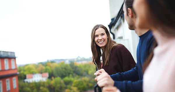 Jente smiler mens hun snakker til et par på visning, til illustrasjon for finansieringsbevis