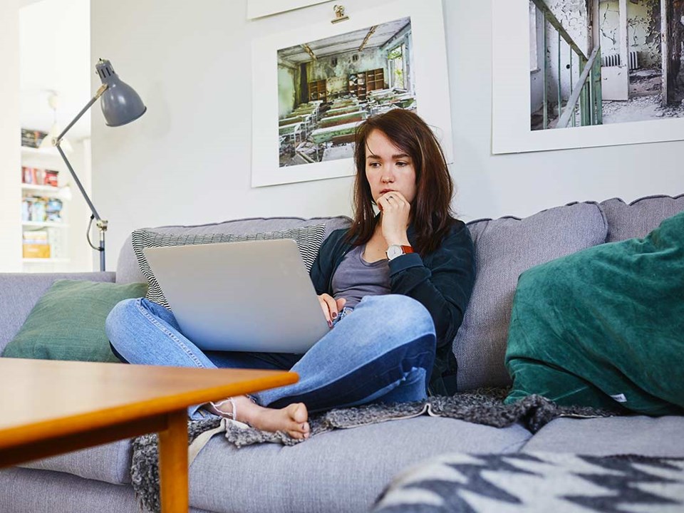 Dame søker etter bolig på pc, til illustrasjon for når er det best å kjøpe bolig