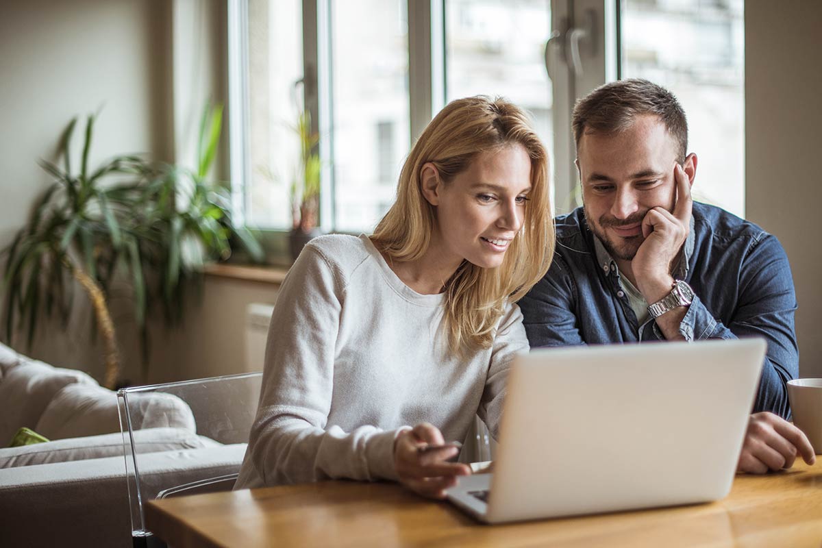 Par ser på laptop, til illustrasjon for refinansiere boliglånet