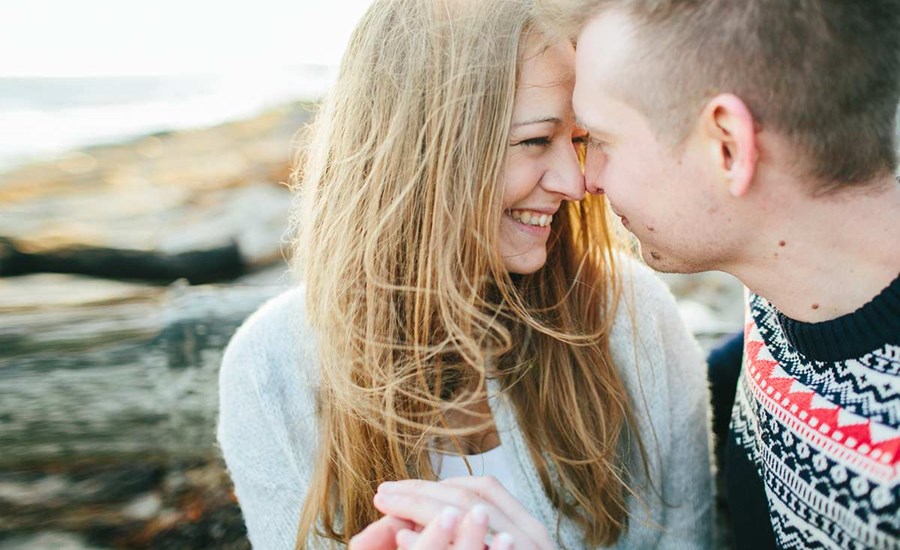Par lener pannen mot hverandre mens de sitter på berget, til illustrasjon for flytte sammen