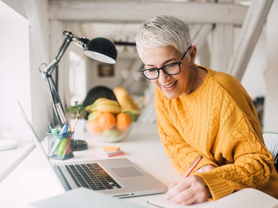 Dame gjør notater hjemme, til illustrasjon for utleie av bolig