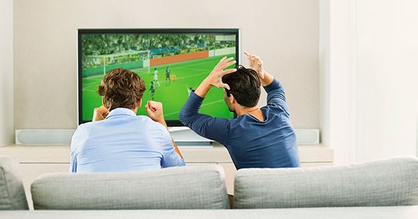 Kamerater ser fotballkamp på tv