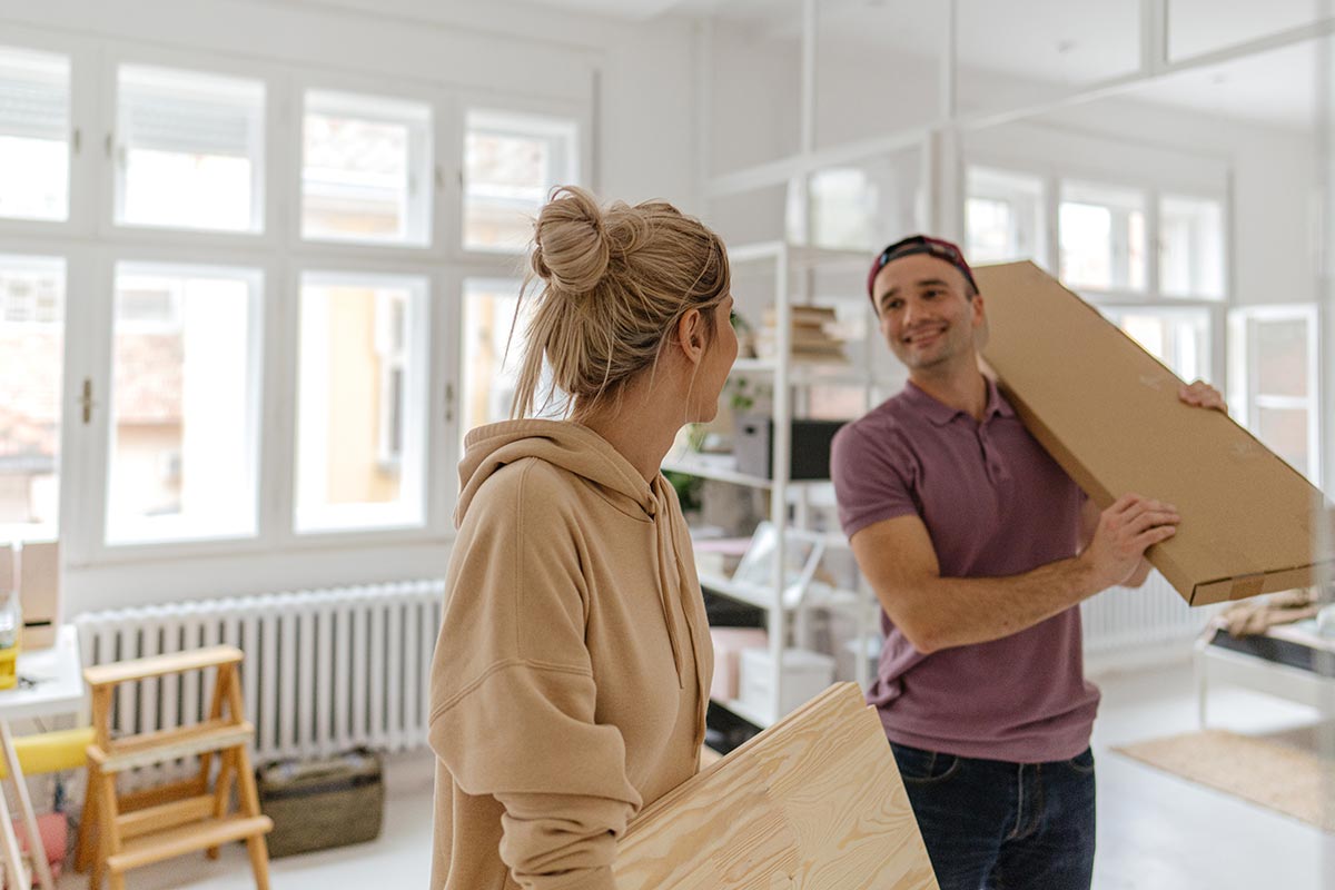 Kvinne og mann holder på esker mens de flytter inn i bolig, til illustrasjon for Finit Deleie
