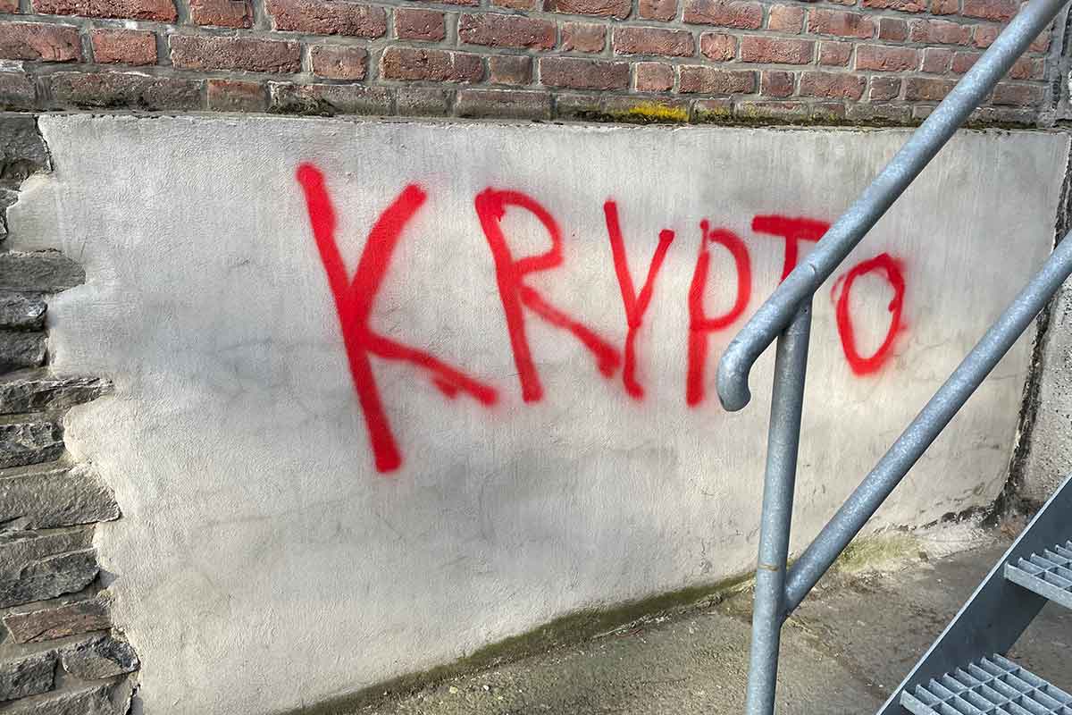 Krypto tagget med rød skrift på bygning, til illustrasjon for kryptovaluta