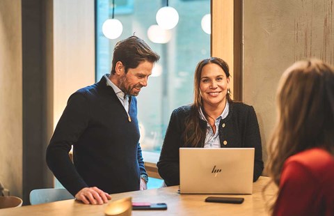 Ansatte i BN Bank sammen rund en pc, illustrasjon til boligsparing