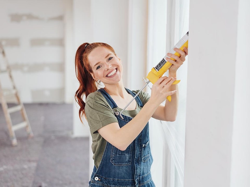 Ung kvinne står i et rom og holder en limpistol, til illustrasjon for hva kan bsu brukes til