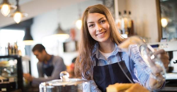 Ung jente jobber som barista på kafé, til illustrasjon for sommerjobb