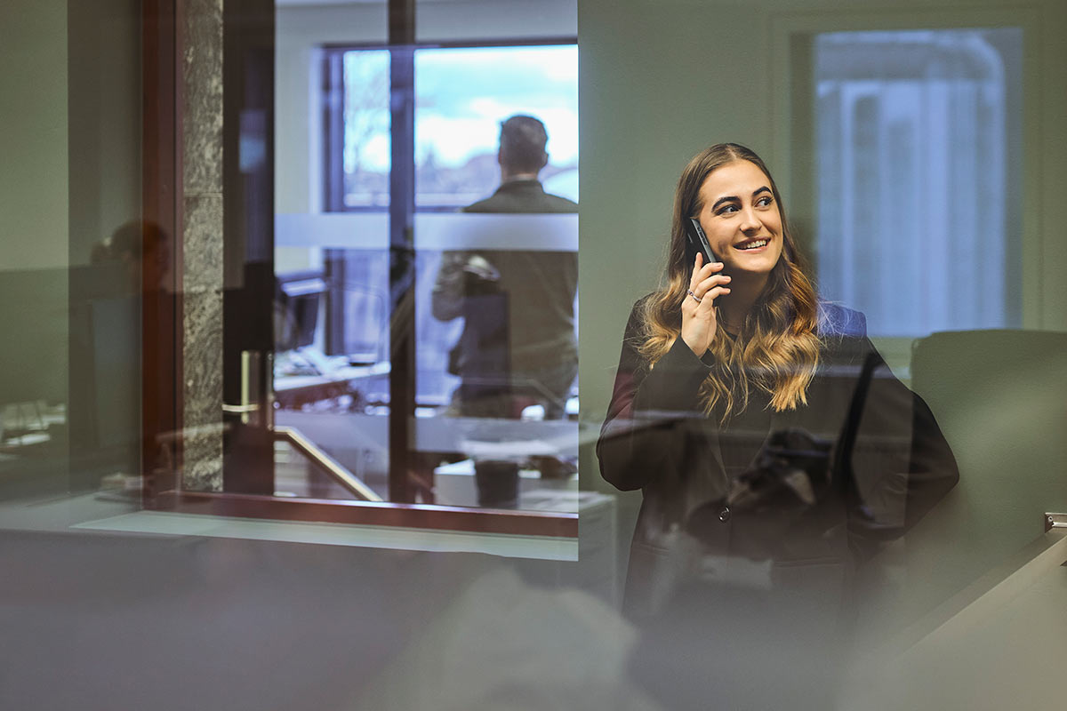 Kvinne som snakker i telefonen, mens hun vurderer fordele ved å ha en høyrentekonto