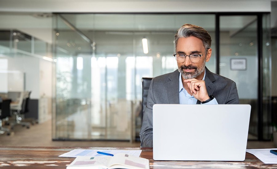 Mann sitter med laptop på kontoret