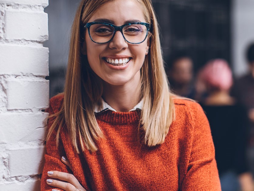 Ung kvinne smiler mens hun er på kontoret