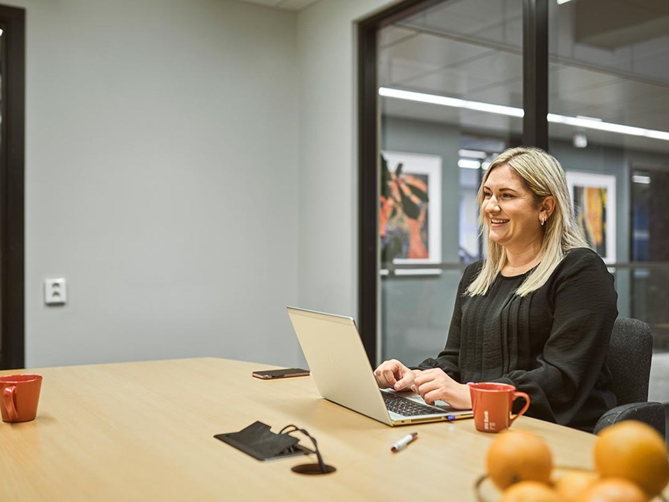 Bedriftsrådgiver Ailin sitter i BN Bank sitt lokale, til illustrasjon for bli bedriftskunde