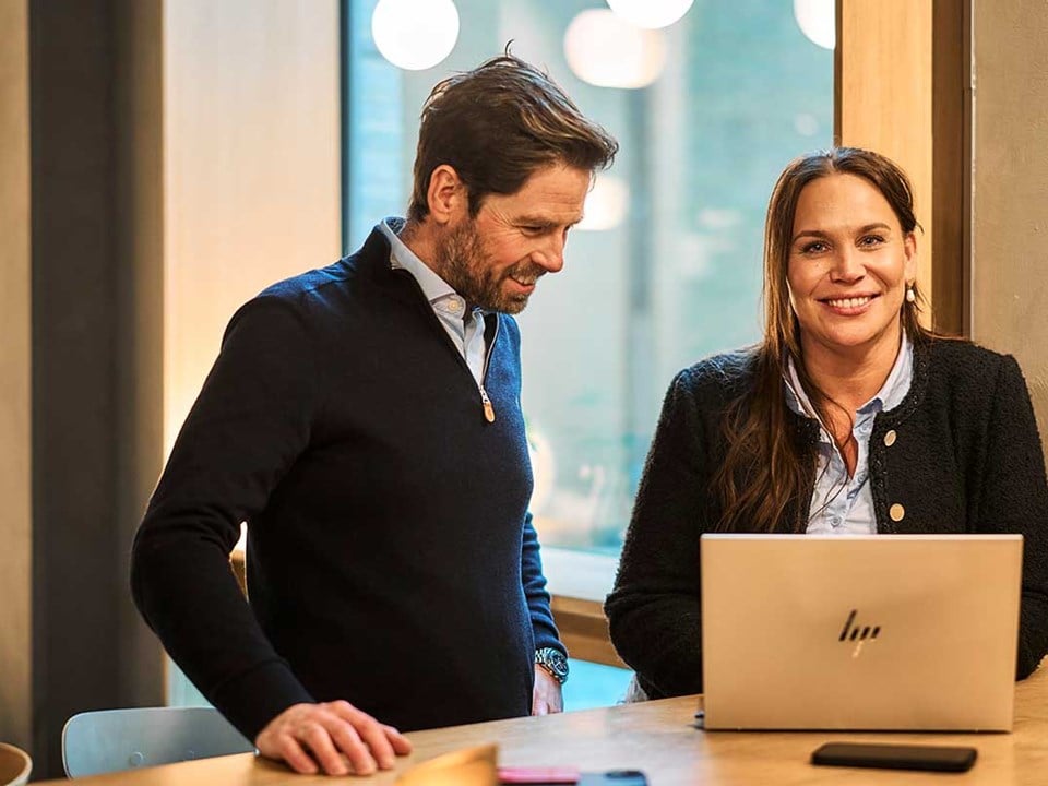 Ansatte i banken ser på laptop