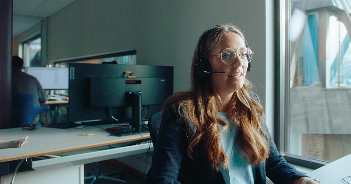 Rådgiver Marit sitter i kontorstol med headset, til illustrasjon for erfaringer med BN Bank