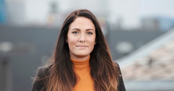 Kunderådgiver Marit smiler mot kamera, til illustrasjon for salg av bolig