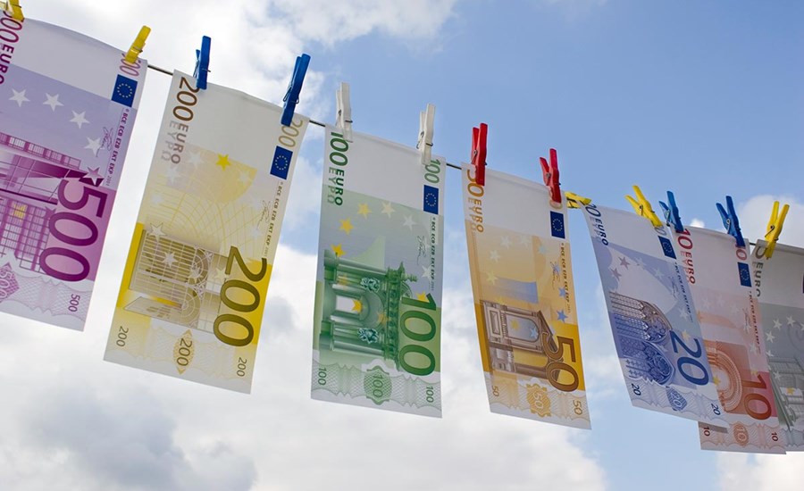 Pengesedler henger til tørk ute i en klessnor, til illustrasjon for antihvitvask