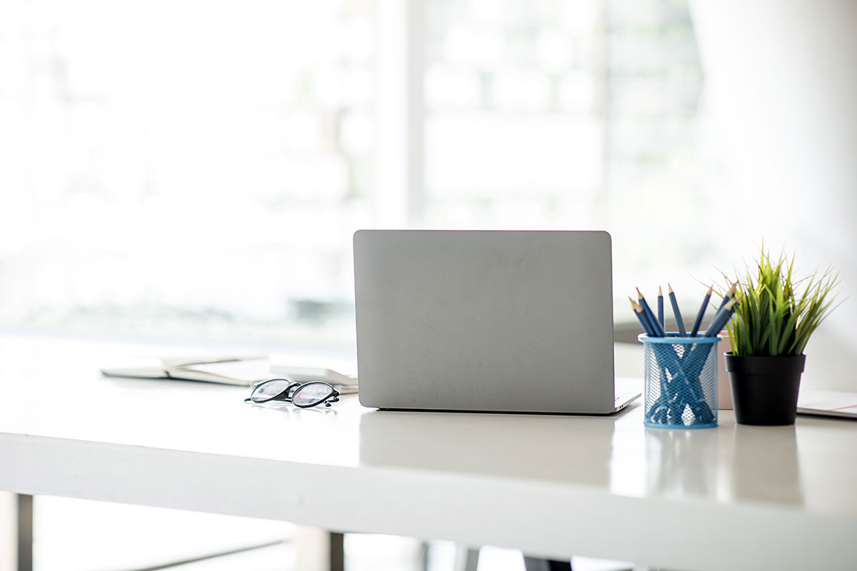 Bok, laptop, briller og blyanter på en skrivepult, til illustrasjon for problemer med innlogging